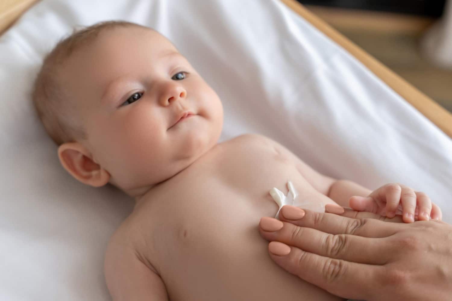 Une mère s'applique une lotion pour soigner la peau de son nouveau-né à la maison